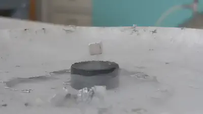 Exemple de l'effet Meissner. Le matériau refroidit à une suffisament basse température (ici avec de l'azote liquide à 77,3K) agit comme un aimant. Ceci s'explique par les paires de Coopers. [Université Paris-Saclay](https://hebergement.universite-paris-saclay.fr/supraconductivite/supra/fr/supra-explication-cooper.php).